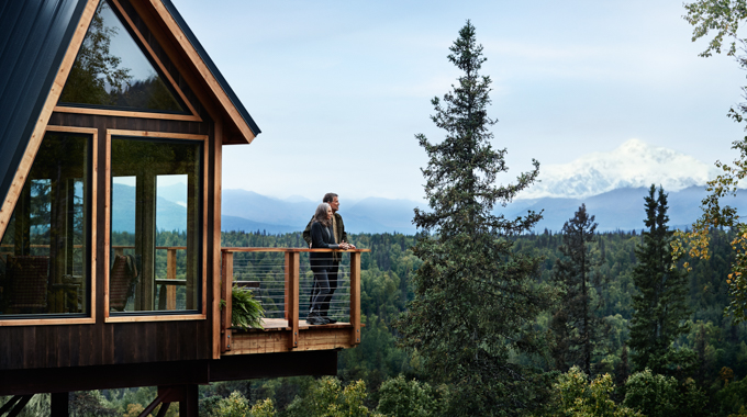 Couple standing on a balcony at Mt. McKinley Princess Wilderness Lodge